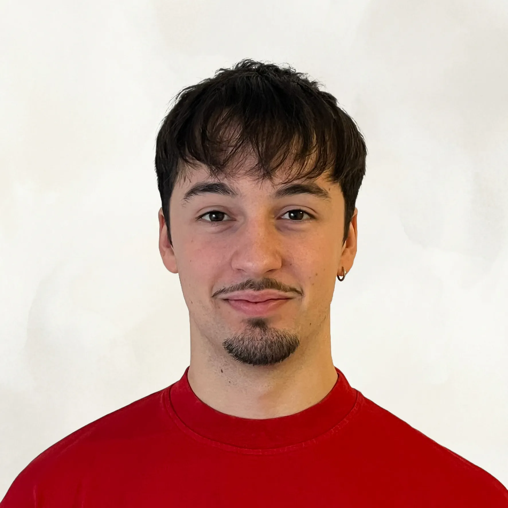 Alejo Arenas smiling in a red plaid shirt